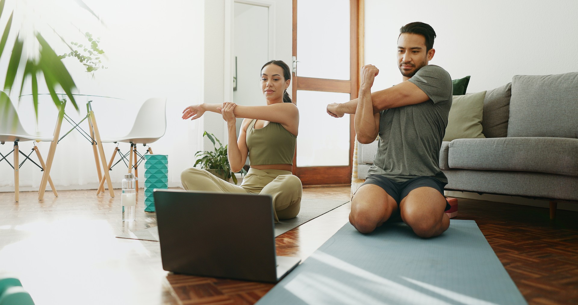 Couple, fitness and stretching with laptop, online class and warm up for exercise and muscle training at home. Workout, internet video and people with sports, wellness and technology for health guide